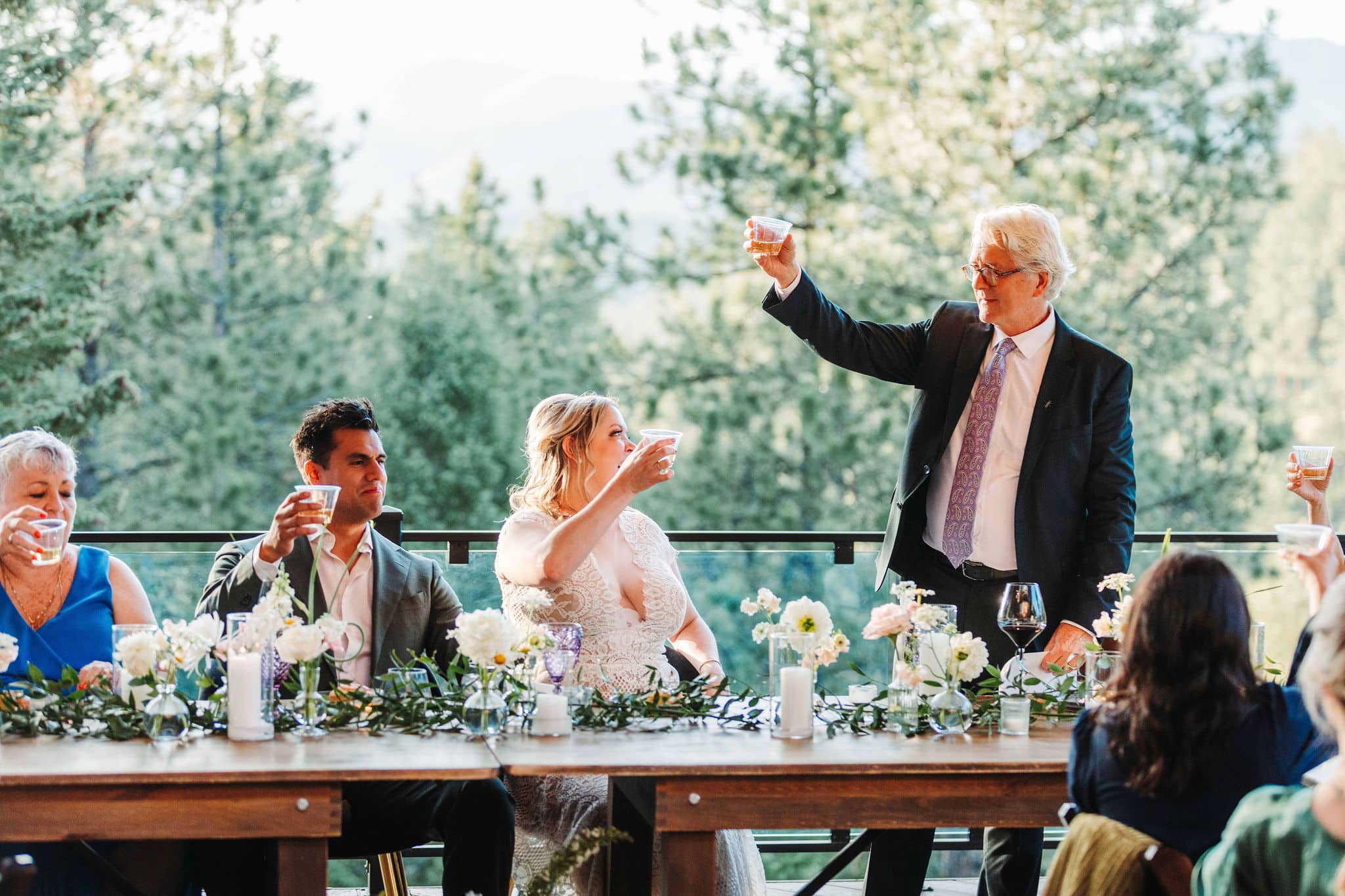 Emily & Adrian raise a glass during toasts at their intimate Colorado micro wedding in Evergreen at Juniper Lodge & Treehouses.