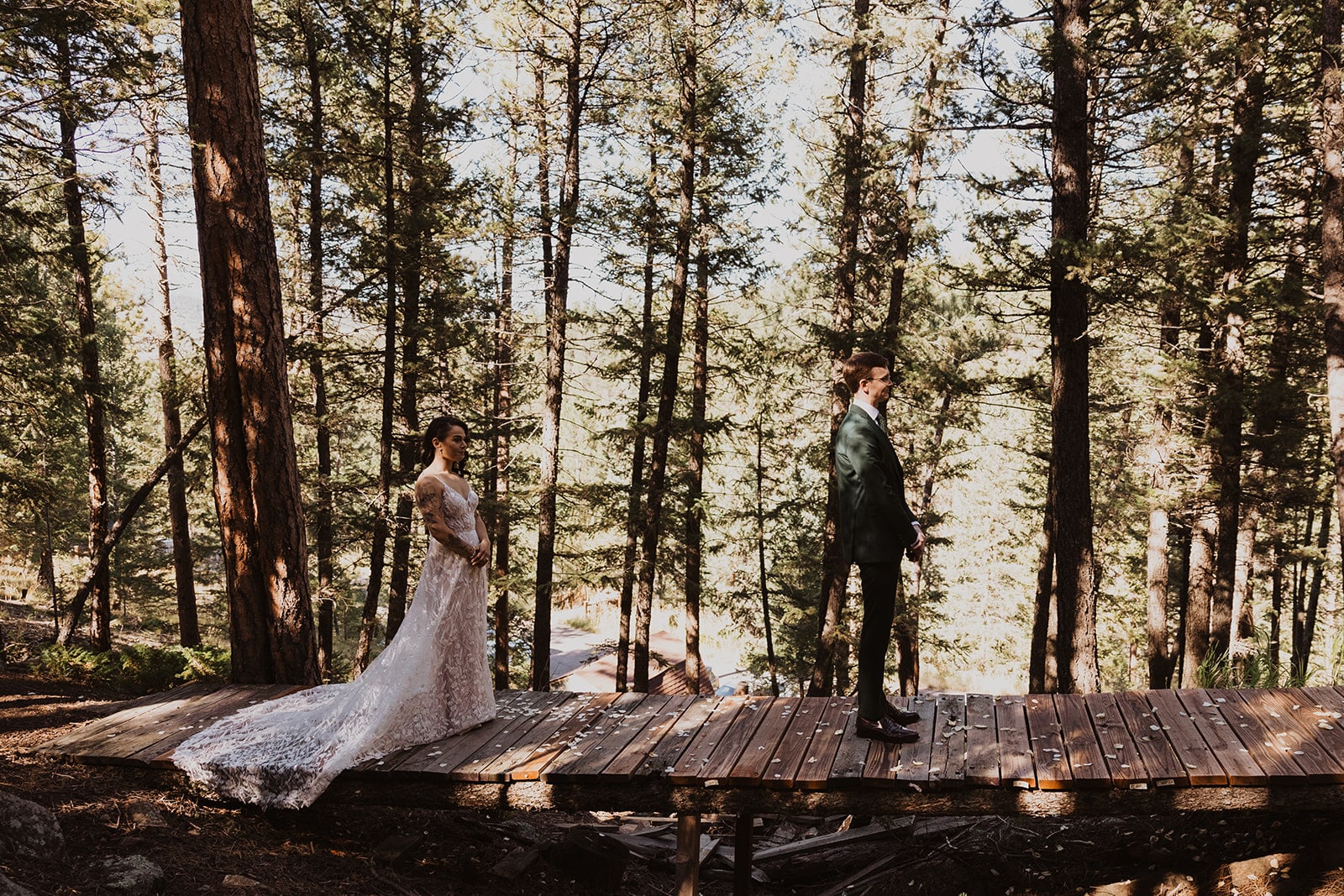 Bride and groom first look on forest bridge during Evergreen wedding at Juniper Lodge & Treehouses.