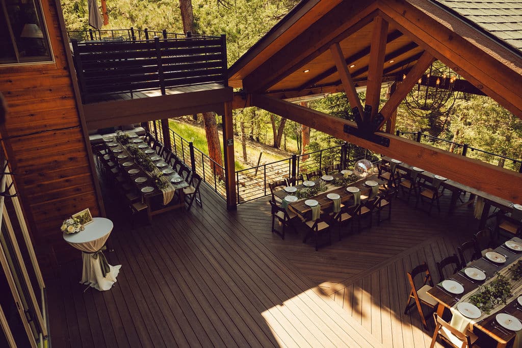 Summer wedding reception dinner on the mountain view deck at Juniper Lodge & Treehouses in Evergreen, Colorado.