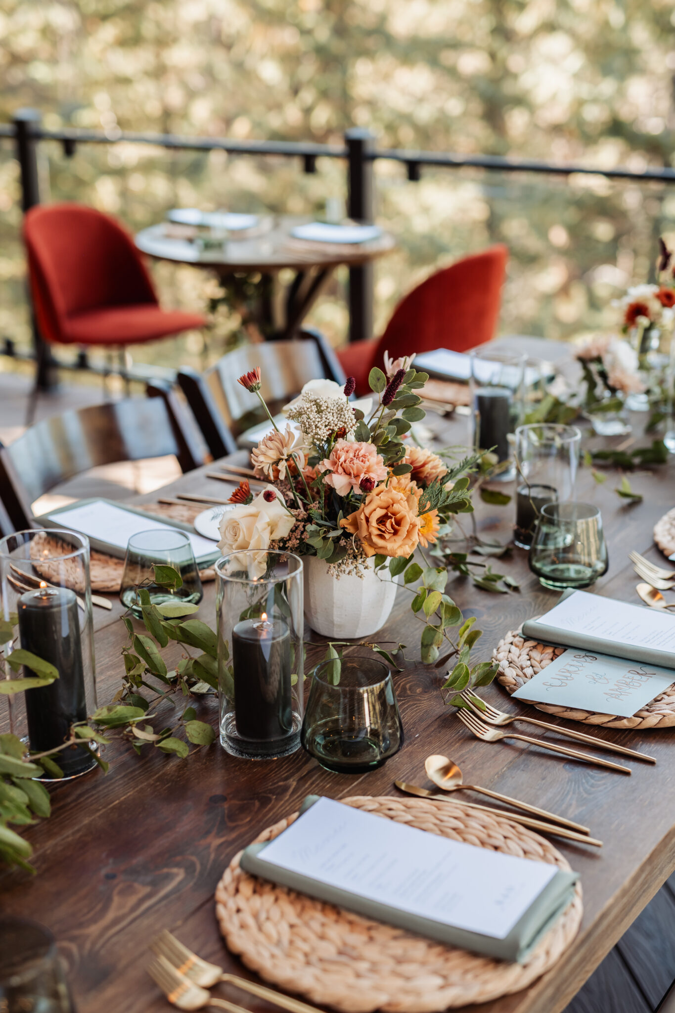 Reception dinner setup with terracotta accents and rattan chargers on the deck at Juniper