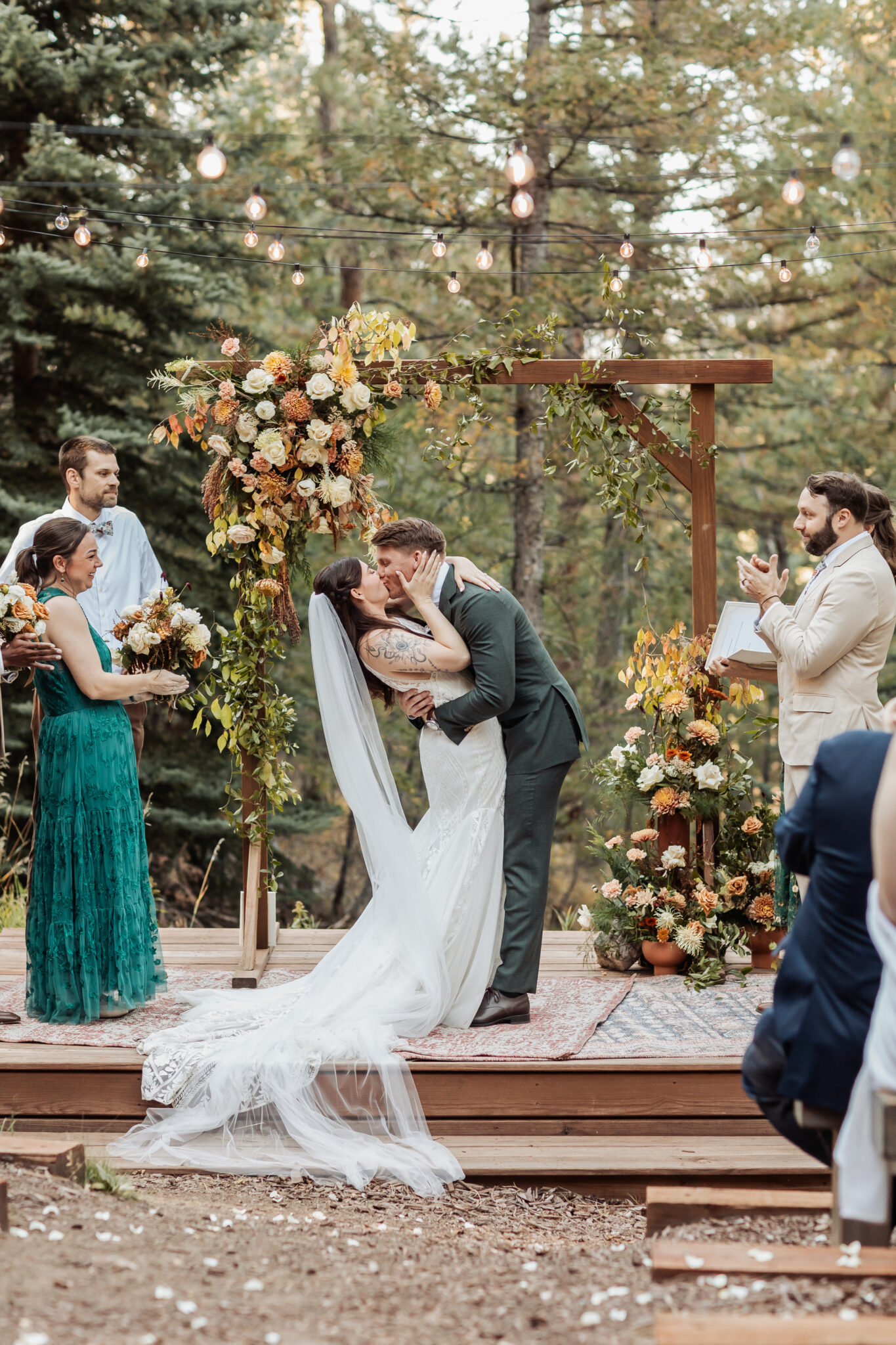 Wedding ceremony under wooden arch with Snowberry Floral arrangements at Juniper Lodge & Treehouses