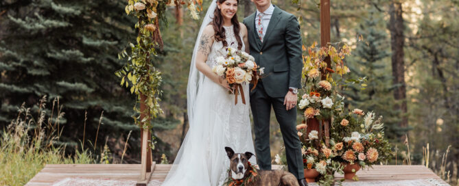 Wedding ceremony under wooden arch with Snowberry Floral arrangements at Juniper Lodge & Treehouses