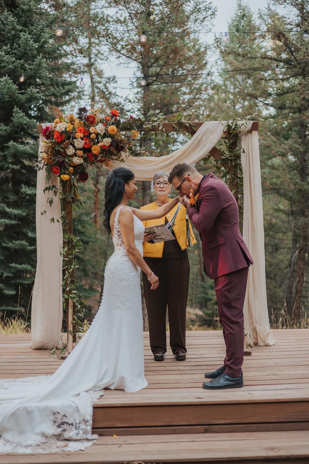 Evergreen autumn wedding ceremony at Juniper Lodge & Treehouses with orange and yellow florals.