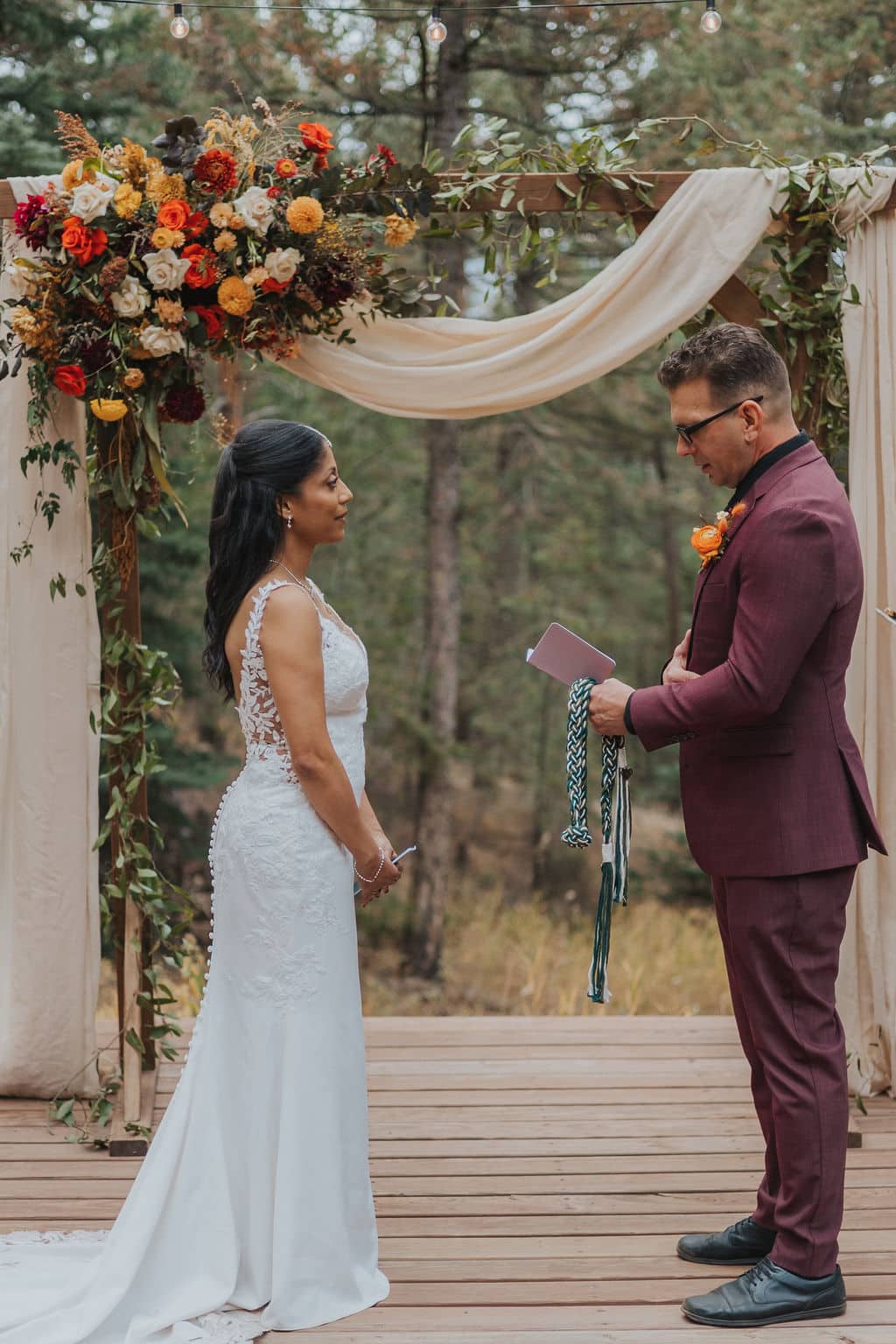 Evergreen autumn wedding ceremony at Juniper Lodge & Treehouses with orange and yellow florals.