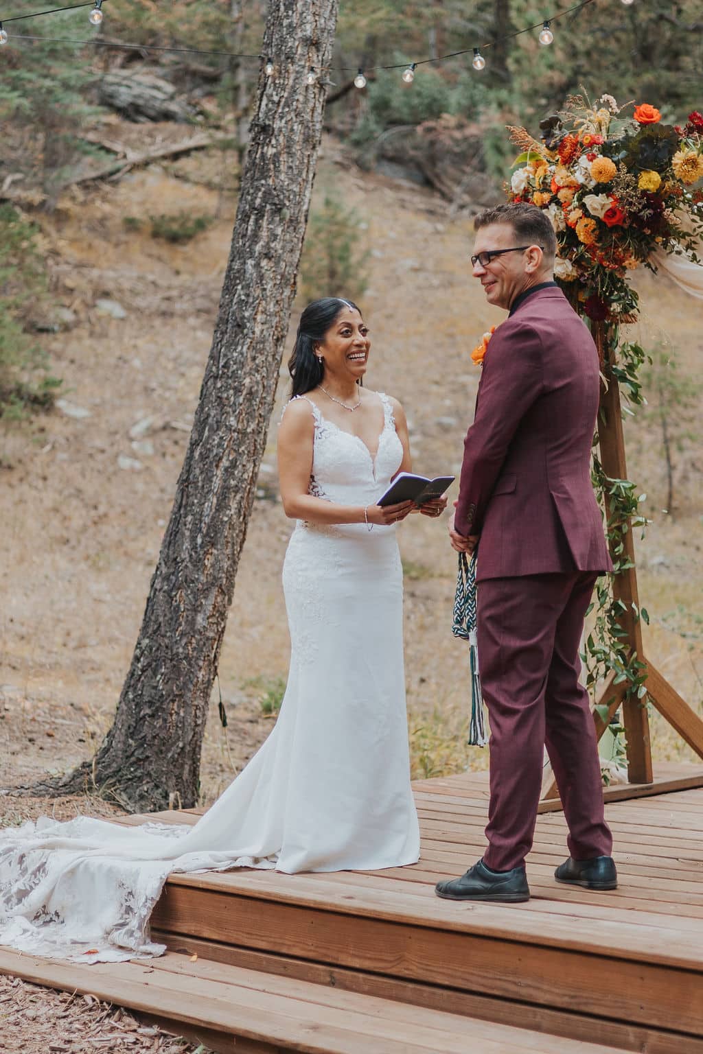 Evergreen autumn wedding ceremony at Juniper Lodge & Treehouses with orange and yellow florals.