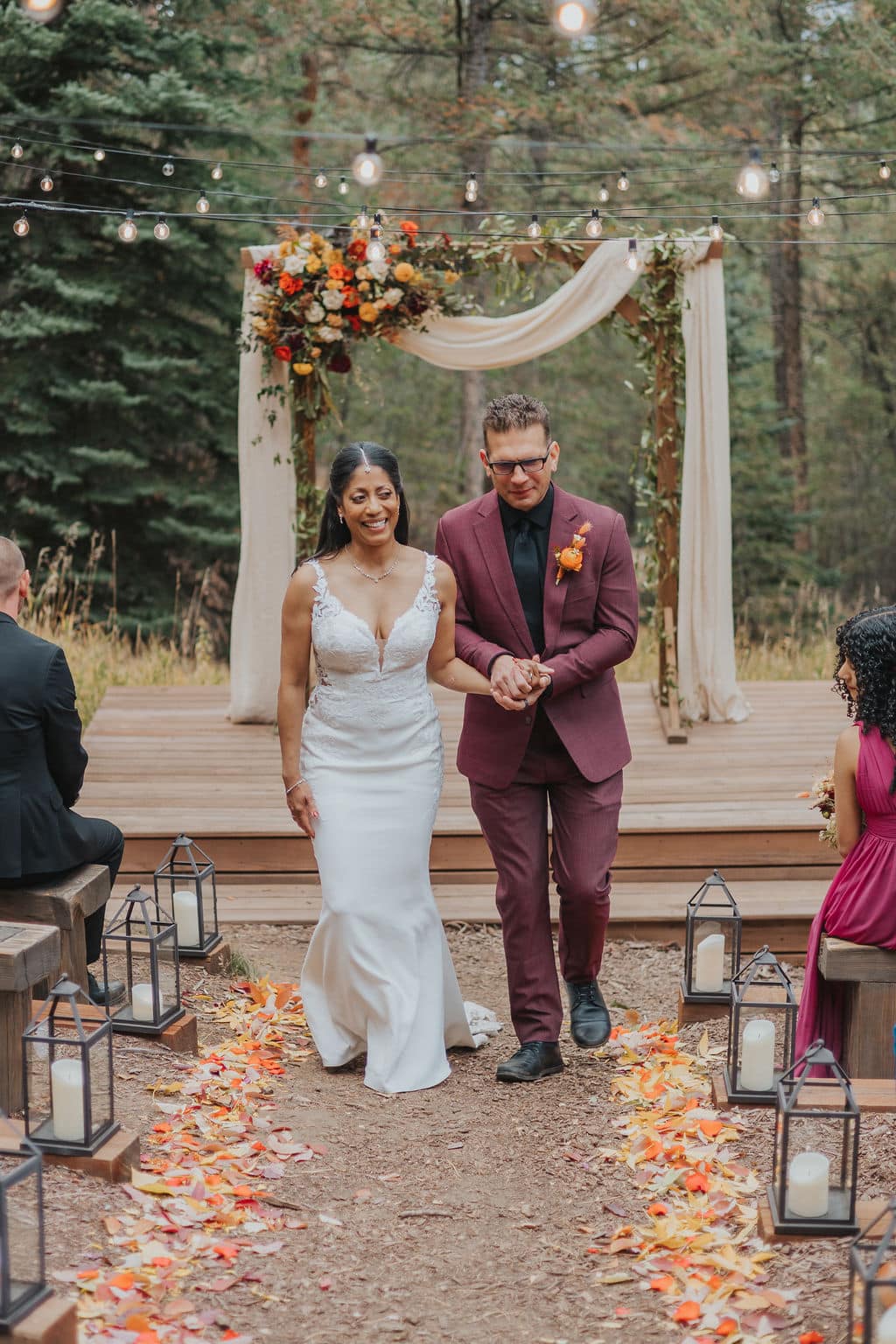 Evergreen autumn wedding ceremony at Juniper Lodge & Treehouses with orange and yellow florals.