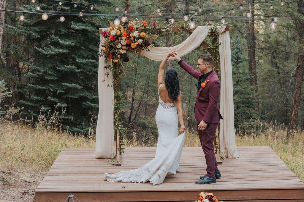 Evergreen autumn wedding ceremony at Juniper Lodge & Treehouses with orange and yellow florals.