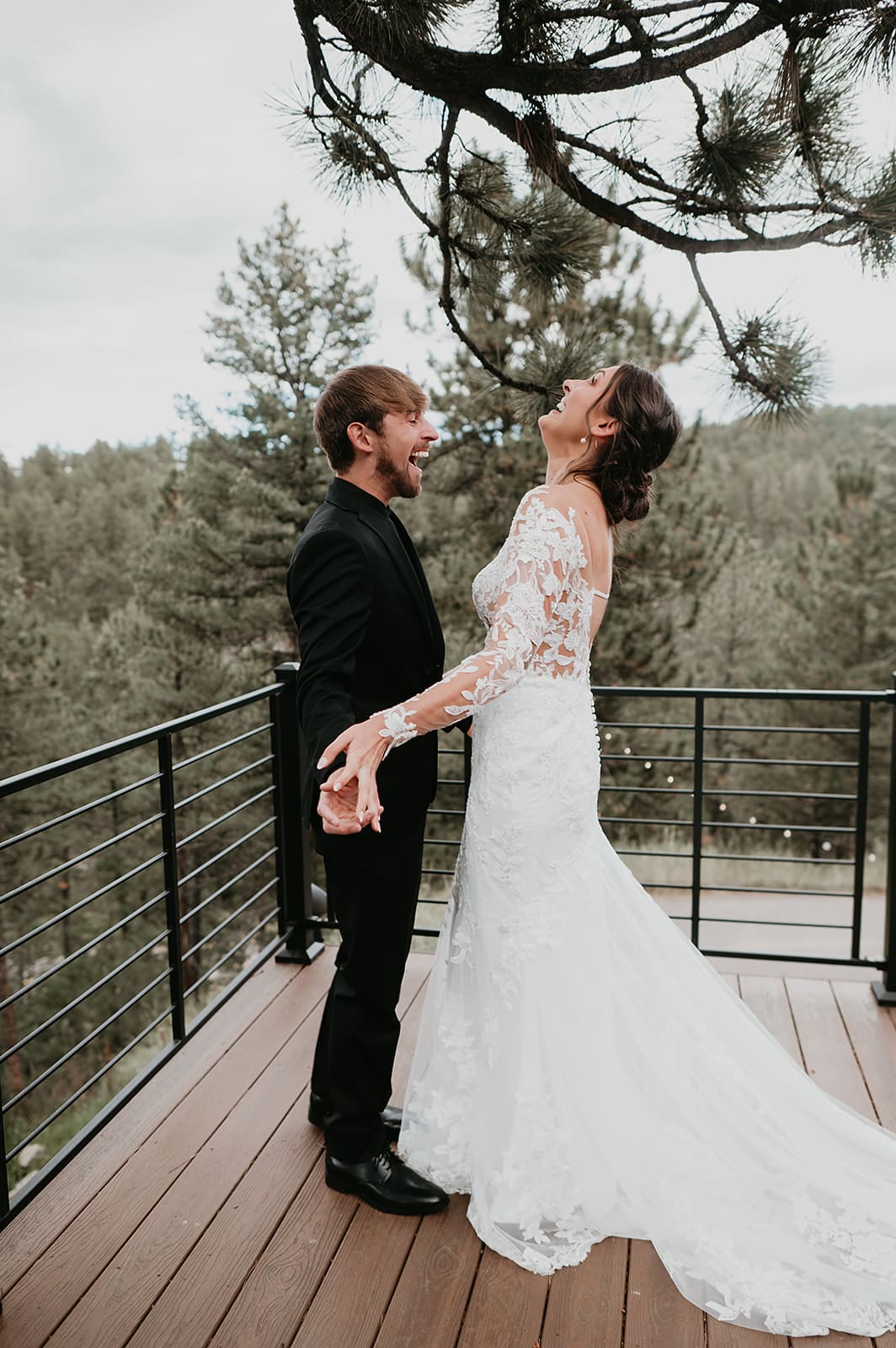 Couple’s first look on the deck surrounded by pine trees and mountain views.