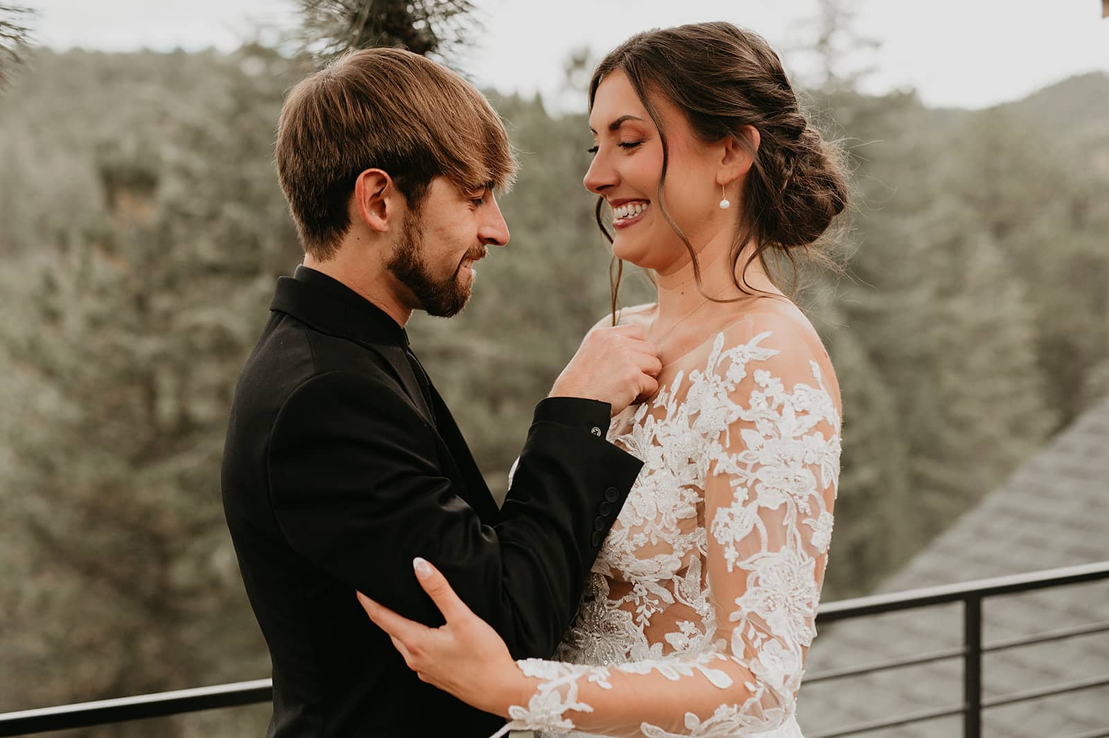Couple’s first look on the deck surrounded by pine trees and mountain views.