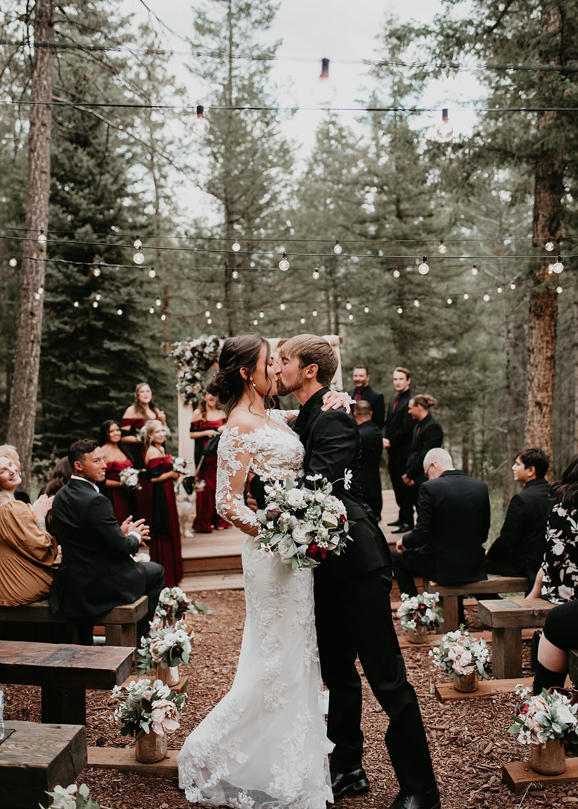 Ceremony in the meadow with string quartet and burgundy floral arch.