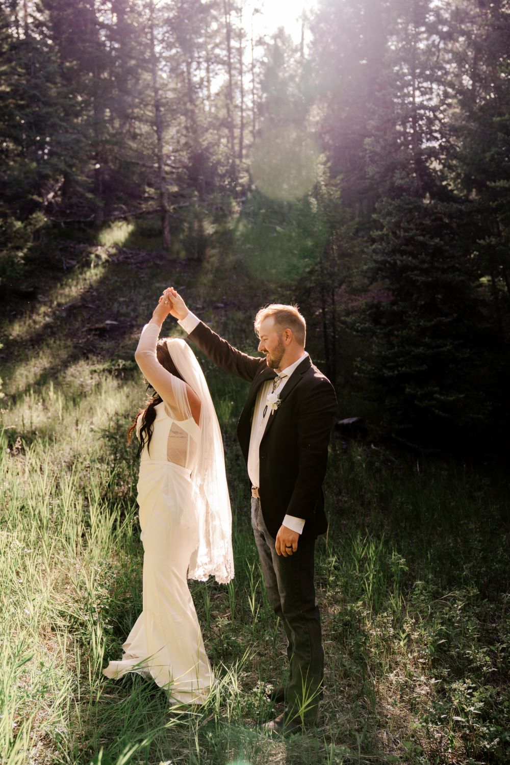 Newlyweds Sam and Cody dance together in the golden hour light at their Evergreen Colorado wedding in the mountains.