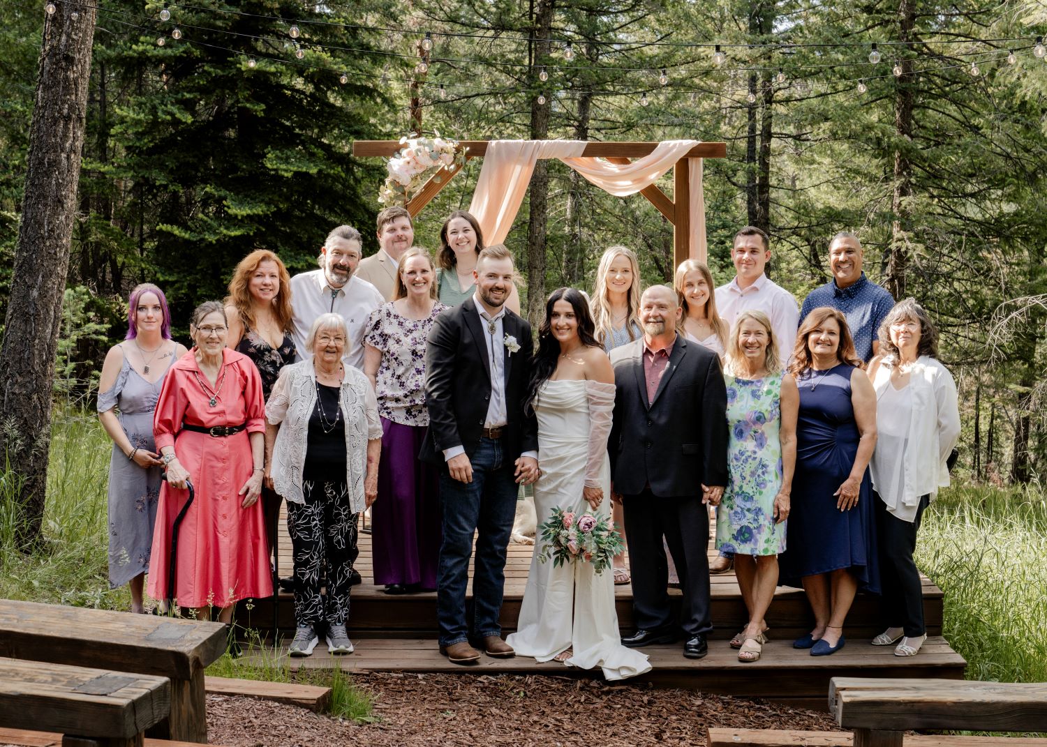 The newlyweds celebrate with family on the ceremony platform following their Evergreen Colorado wedding at Juniper Lodge & Treehouses.