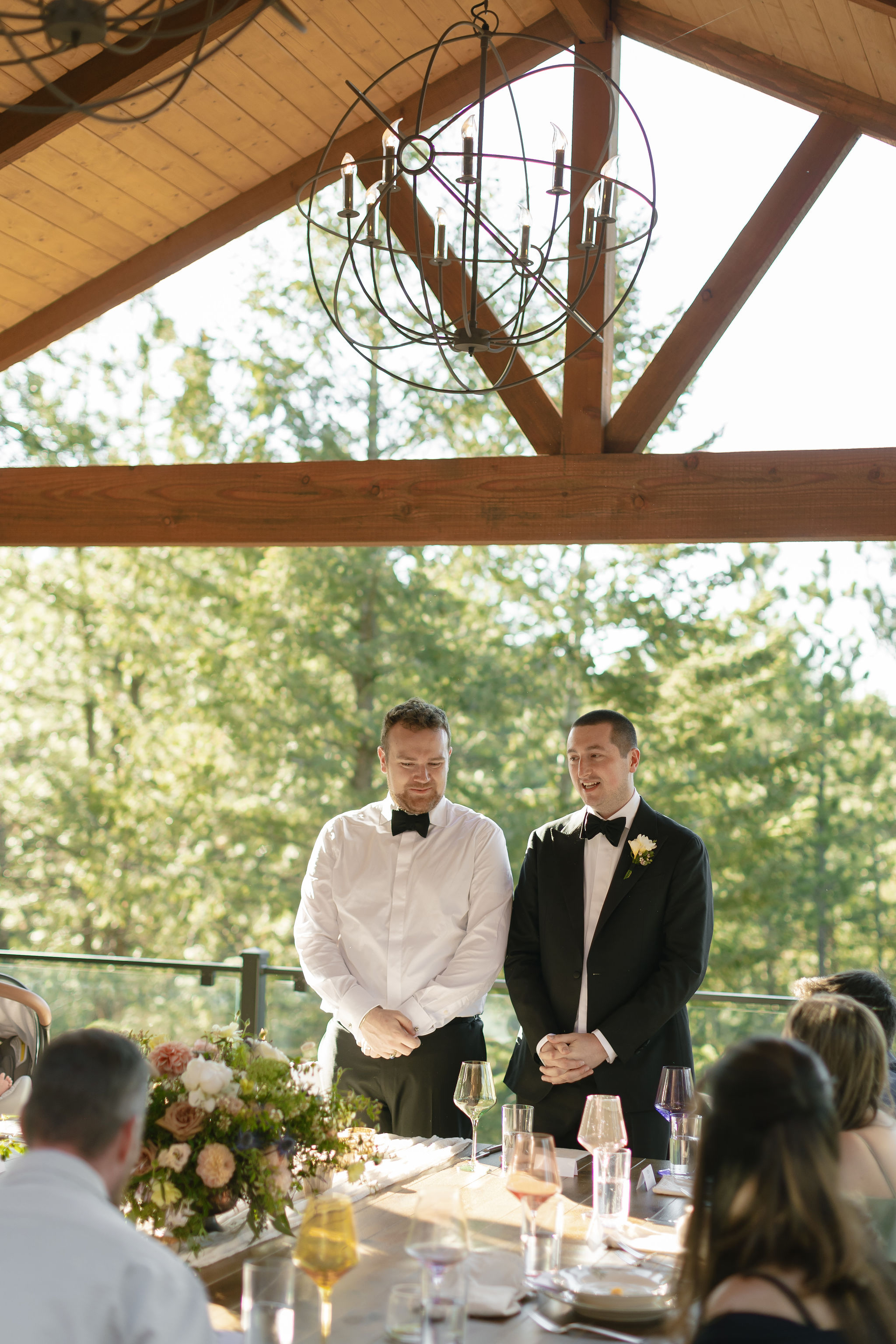 Ty and Tyler give a toast at their Evergreen Colorado micro wedding at Juniper Lodge & Treehouses.