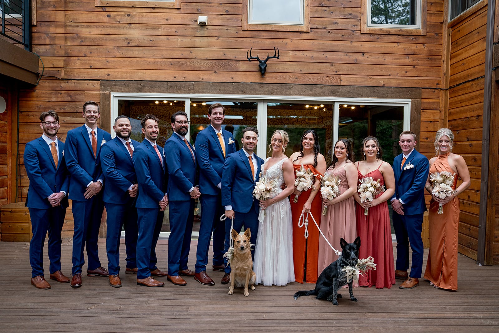 Wedding party in terracotta dresses and blue suits with orange ties