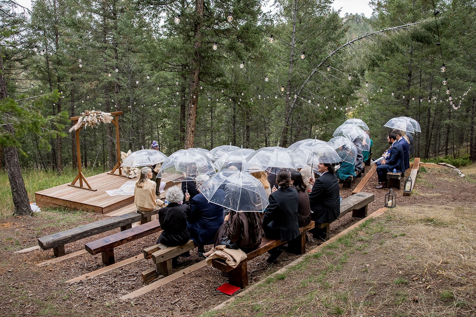 Rainy Colorado wedding at Juniper Lodge & Treehouses with clear umbrellas.