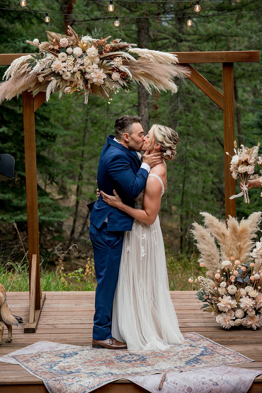 Bride and groom first kiss during their fall mountain wedding at Juniper Lodge & Treehouses