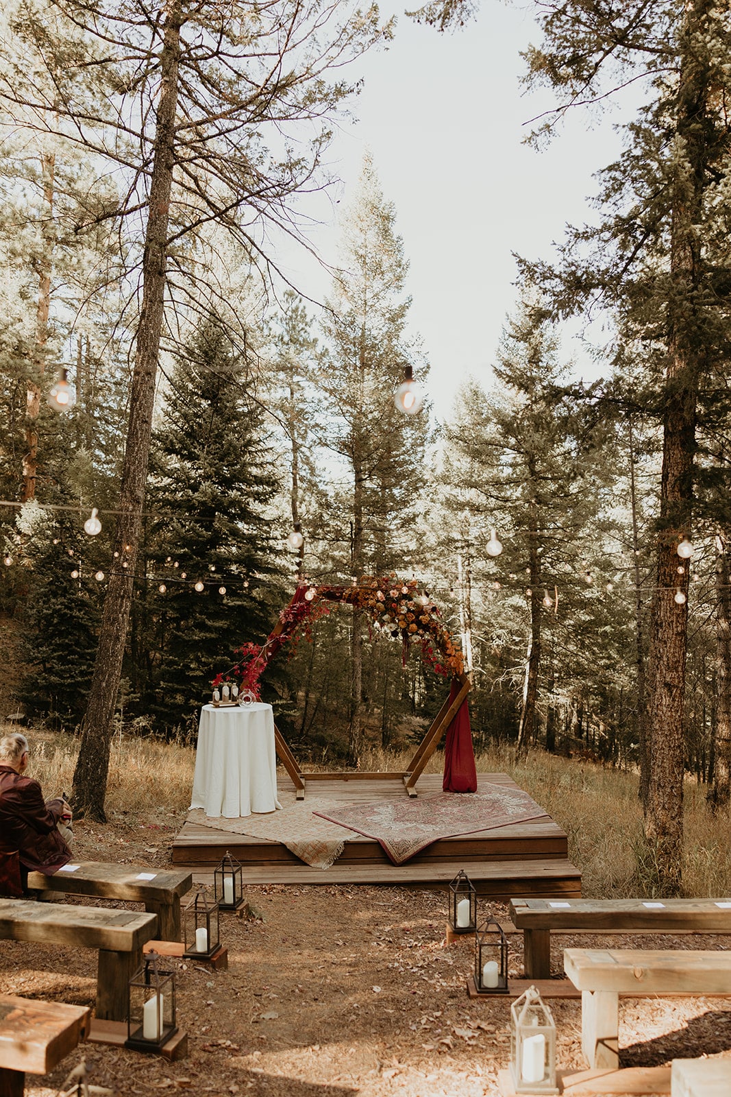 Meadow ceremony with hexagon arch and rust drapery at Juniper Lodge & Treehouses.