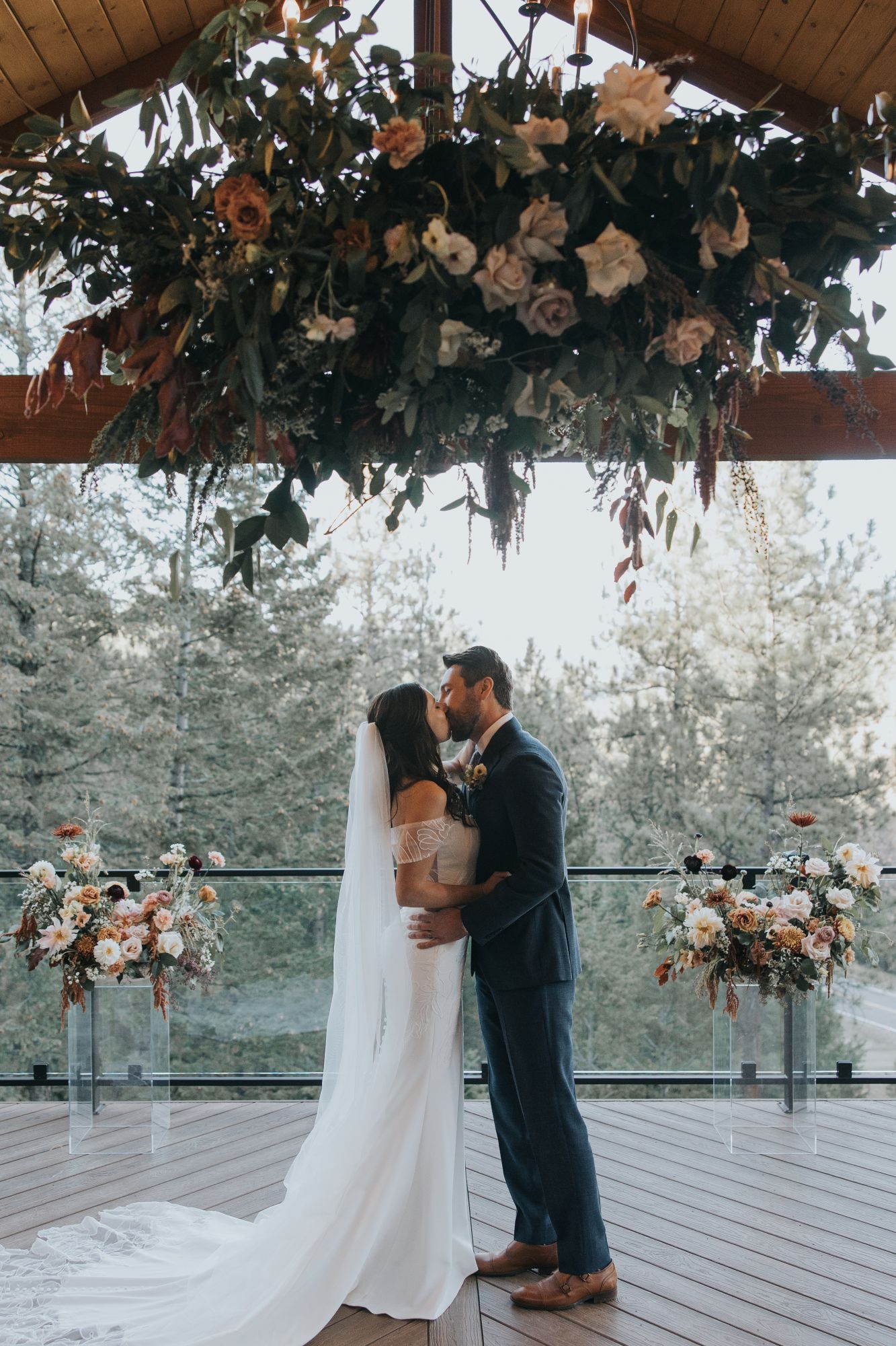 First kiss at micro wedding on the Mountain View Deck at Juniper Lodge & Treehouses in Evergreen, Colorado